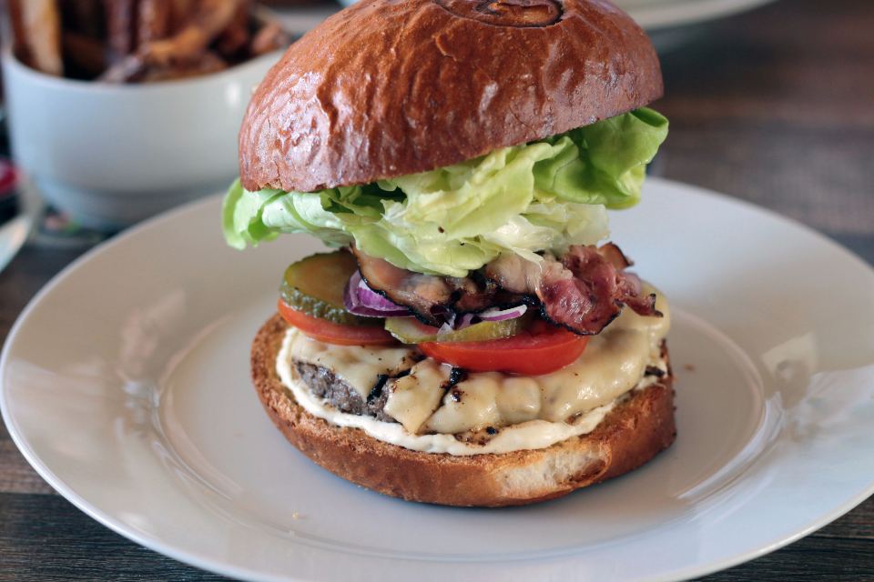Burger with fresh salad on a white plate
